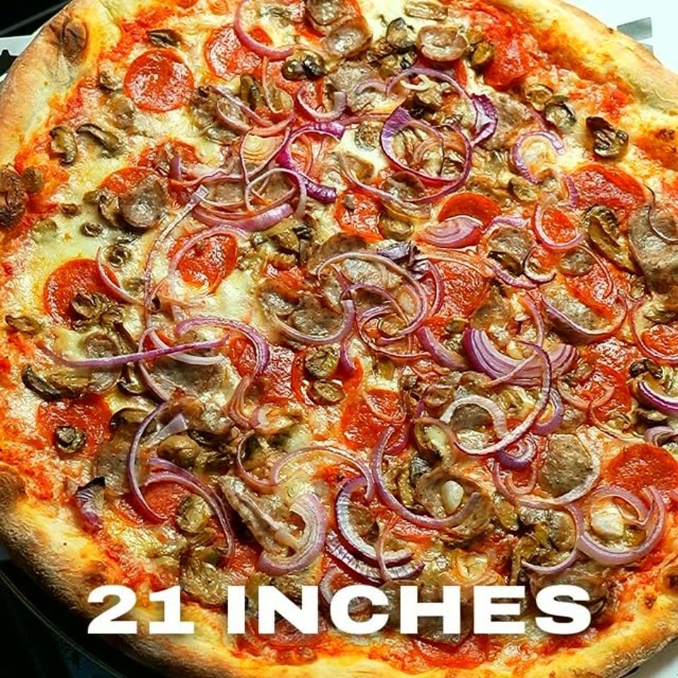 Large 21-inch pizza topped with pepperoni, mushrooms, and red onions on colorful branded paper.